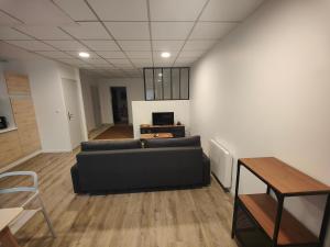 サン・テニャンにあるStudio des quaisのソファとテーブルのあるリビングルーム