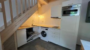 una cucina con lavatrice e asciugatrice accanto a una scala di Casa CARMUCHI a Noriega