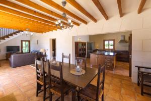 a kitchen and living room with a wooden table and chairs at Finca Poas in Es Llombards