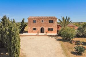 an external view of a stone house with a driveway at Finca Poas in Es Llombards