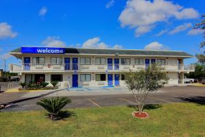 a hotel building with a blue sign on it at Motel 6-Kingsville, TX in Kingsville