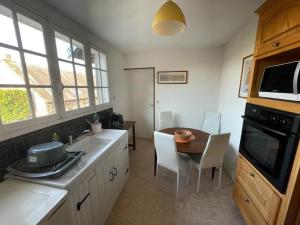 a kitchen with a table and a dining room at L Ancienne Ferme in Connantre