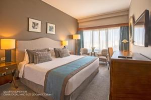 a hotel room with a large bed and a desk at Santarem Hotel in Santarém