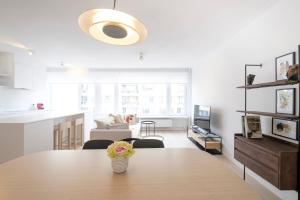 a room with a table with a vase of flowers on it at Trendy 1 bedroom flat near Schuman and Berlaymont in Brussels