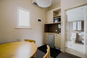 a kitchen with a table, chairs and a microwave at The Studios by Haus, Ascend Hotel Collection in Hahndorf