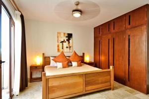 a bedroom with a bed with orange pillows at Acanto Hotel Playa del Carmen, Trademark Collection by Wyndham in Playa del Carmen