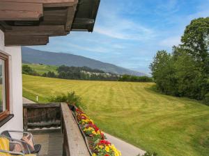 a balcony with flowers and a view of a field at Apartment Jägerhof-2 by Interhome in Hochpillberg