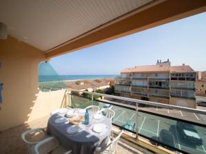 a balcony with a table and a view of the ocean at Apartment Les Flots Bleus by Interhome in Le Barcarès