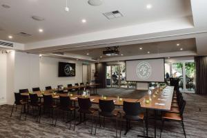 a conference room with a long table and chairs and a screen at The Lodge in Hahndorf