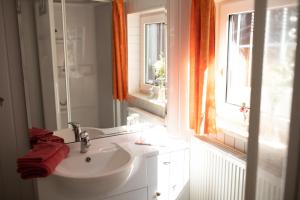 ein weißes Bad mit einem Waschbecken und einem Fenster in der Unterkunft Ferienwohnung-Ihle Olbernhau in Olbernhau