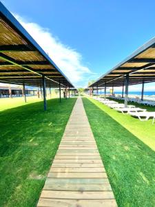 een loopbrug naast het strand met een groot gebouw bij İstanbul Beach Hotel in Kemer