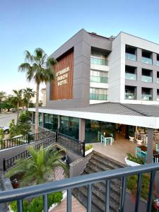 ケメルにあるİstanbul Beach Hotelのヤシの木が茂るホテルの正面の景色を望めます。