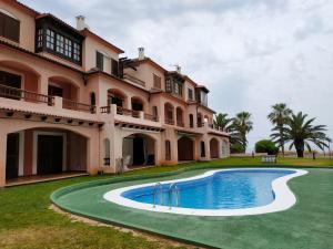 an exterior view of a large house with a swimming pool at Adosado Puntamer Orangecosta in Peñíscola