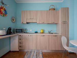 una cucina con armadi in legno e forno a microonde di Apartment Les Maisons della Fattoria 1 by Interhome a Omegna