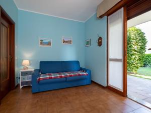 eine blaue Couch in einem Wohnzimmer neben einer Tür in der Unterkunft Apartment Les Maisons della Fattoria 1 by Interhome in Omegna