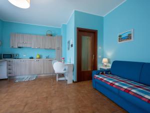 ein blaues Wohnzimmer mit einem Sofa und einer Küche in der Unterkunft Apartment Les Maisons della Fattoria 1 by Interhome in Omegna
