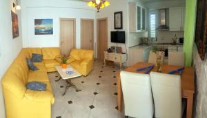 a living room with a yellow couch and a table at Apartmani Villa Rep in Blace