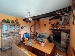 a living room with a wooden table and a fireplace at Chalet Merlo by Interhome in Porlezza