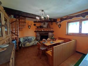 a living room with a table and a fireplace at Chalet Merlo by Interhome in Porlezza