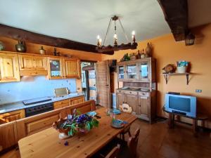 a kitchen with a wooden table and a television at Chalet Merlo by Interhome in Porlezza +34 photos