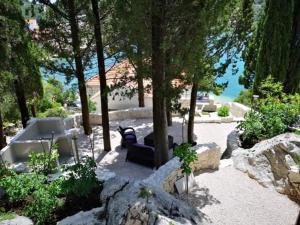 a patio with a table and chairs under a tree at Apartmani Villa Rep in Blace