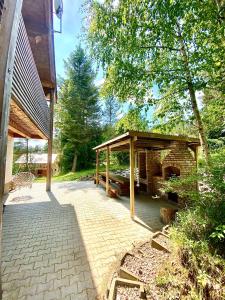 a patio with a pavilion and a stone fireplace at Chata Paradise in Smižany