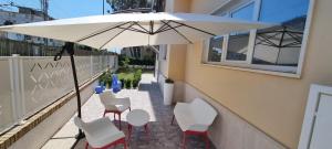 einen Tisch und Stühle unter einem Sonnenschirm auf dem Balkon in der Unterkunft Casa Trilli in Grottammare