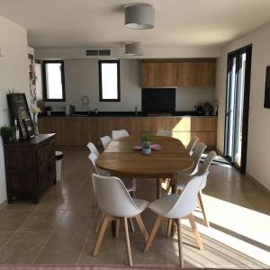 a wooden table and white chairs in a kitchen at Two Sisters House, Private pool & bike storage, Mont-Ventoux, lac Palivettes, Child-friendly in Malaucène