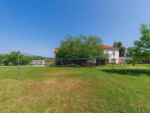 a large yard with a volleyball net in the grass at Apartment Vesela-1 by Interhome in Savudrija