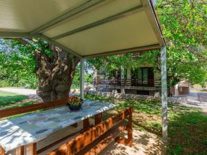 a porch with a table on a wooden bench at Apartment Vesela-3 by Interhome in Savudrija