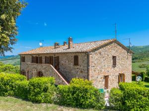 an old stone house with bushes in front of it at Apartment Podere Cafaggiolo-3 by Interhome in Volterra