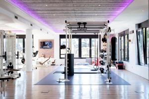 un gimnasio con techos púrpuras y una gran sala con aparatos de gimnasia en monte mare SAUNA-SPA-SPORTS-HOTEL, en Andernach