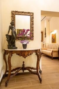 a mirror on top of a table with a statue at Kings Home In Rome in Rome