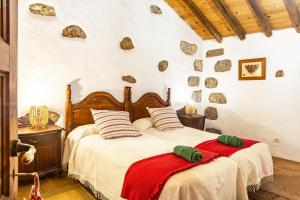 two beds in a bedroom with rocks on the wall at Casa Rural La Caldera in Teror +24 photos