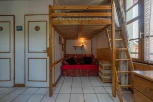 Cama elevada en habitación con cama roja en Studio en centre village St Gervais en Saint-Gervais-les-Bains