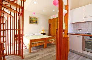 1 Schlafzimmer mit einem Bett und einer Küche in der Unterkunft Apartment Diego 2160 in Pula