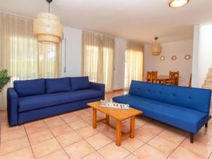 a living room with blue couches and a coffee table at Villa Villa Cala Nova B by Interhome in Les tres Cales +17 photos