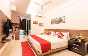 a bedroom with a large bed and a television at Octave Golfcourse Inn in Gurgaon