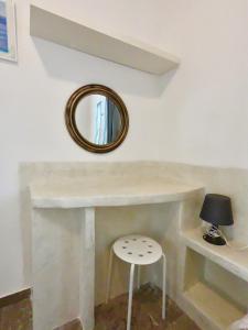 a mirror sitting on top of a counter with a stool at Anny Studios Perissa Beach in Perissa