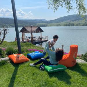 a woman playing with a child on some inflatable chairs by the water at Nefes Dağyenice Doğada in Bursa