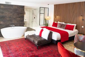 a bedroom with a large bed and a bath tub at Le Confidentiel Hôtel & SPA in Saint-Raphaël