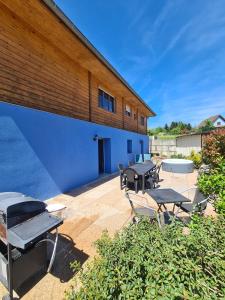 eine Terrasse mit Tischen und Stühlen vor einem Gebäude in der Unterkunft Agréable appartement avec Spa proche de la forêt in Bréchaumont