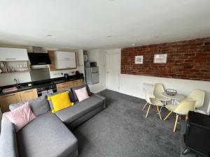 a living room with a couch and a table and a brick wall at The Old Wig Shop in Southport