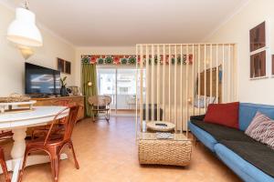 a living room with a couch and a table at Cabanas Green Apartment & Loft. in Cabanas de Tavira