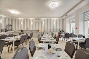 jadalnia ze stołami i krzesłami oraz kuchnia w obiekcie Soplicowo w mieście Krynica Zdrój