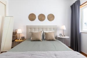 um quarto branco com uma cama grande e 2 candeeiros em Cabanas Green Apartment & Loft. em Cabanas de Tavira