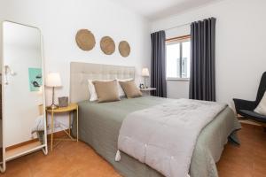 um quarto com uma cama grande e um espelho em Cabanas Green Apartment & Loft. em Cabanas de Tavira