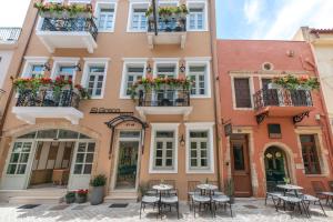 een gebouw met tafels en stoelen ervoor bij El Greco Hotel in Chania