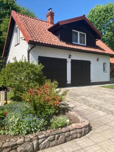 uma casa com uma garagem a preto e branco em Magnolia em Kruklanki