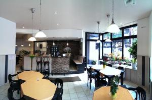 ein Restaurant mit Tischen und Stühlen und eine Küche in der Unterkunft Hotel Klenkes am Bahnhof in Aachen